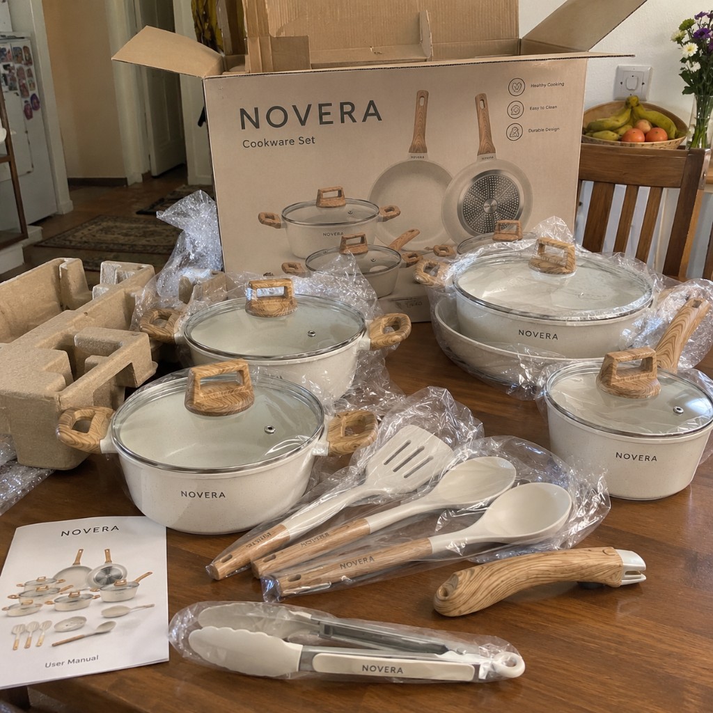 Komplettes NOVERA Kochgeschirr-Set unverpackt auf dem Tisch mit Deckeln und Utensilien
